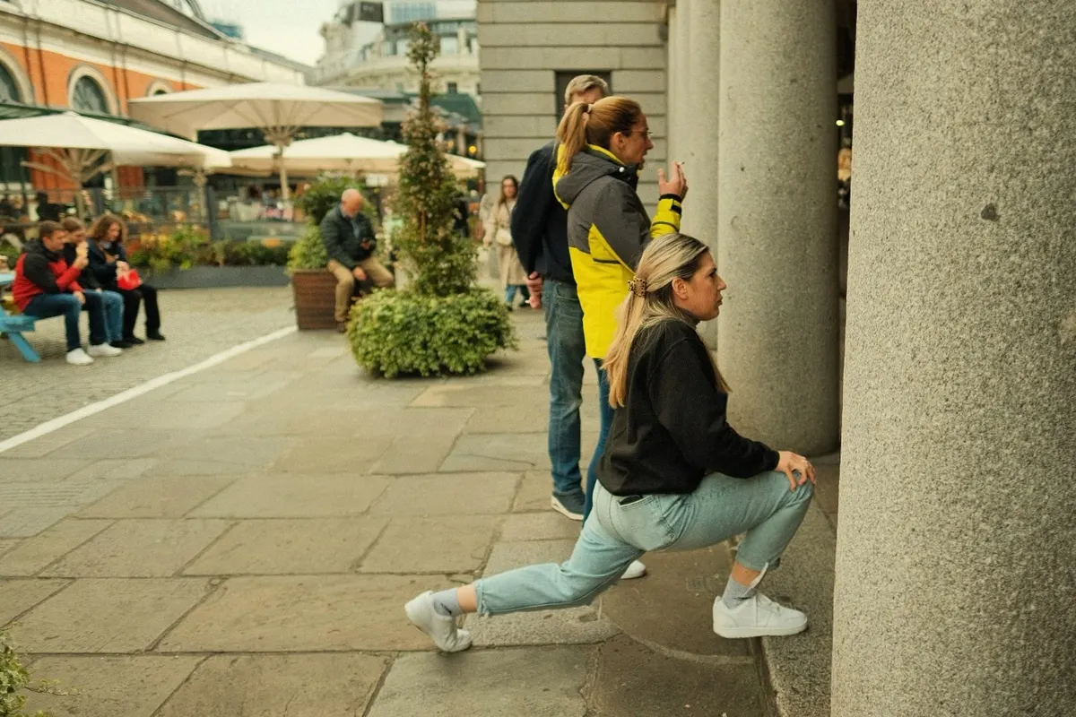 A woman mid-stride by a column in Covent Garden, London street photography