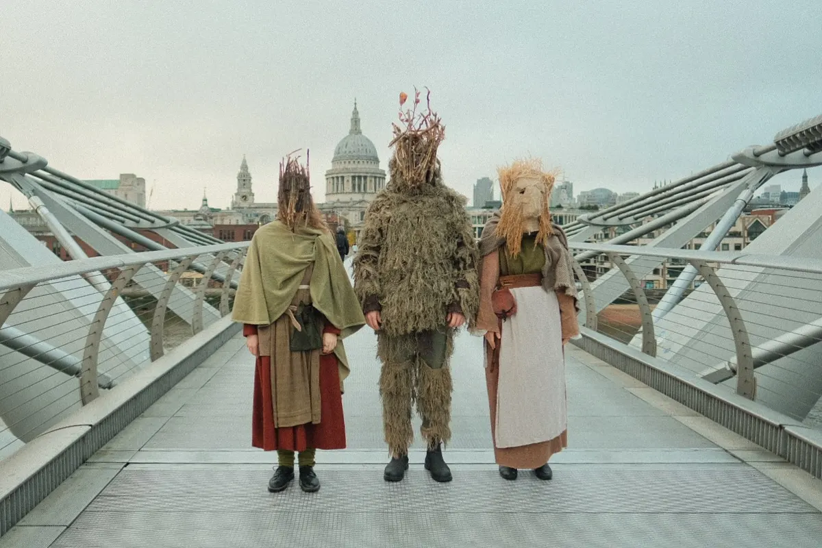 Costumed figures on the Millennium Bridge with St Paul’s behind, London
