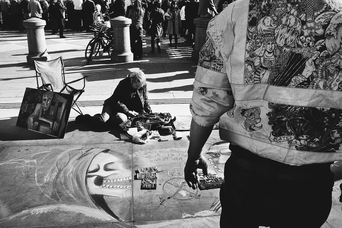 A pavement chalk artist and crowd near Trafalgar Square, London